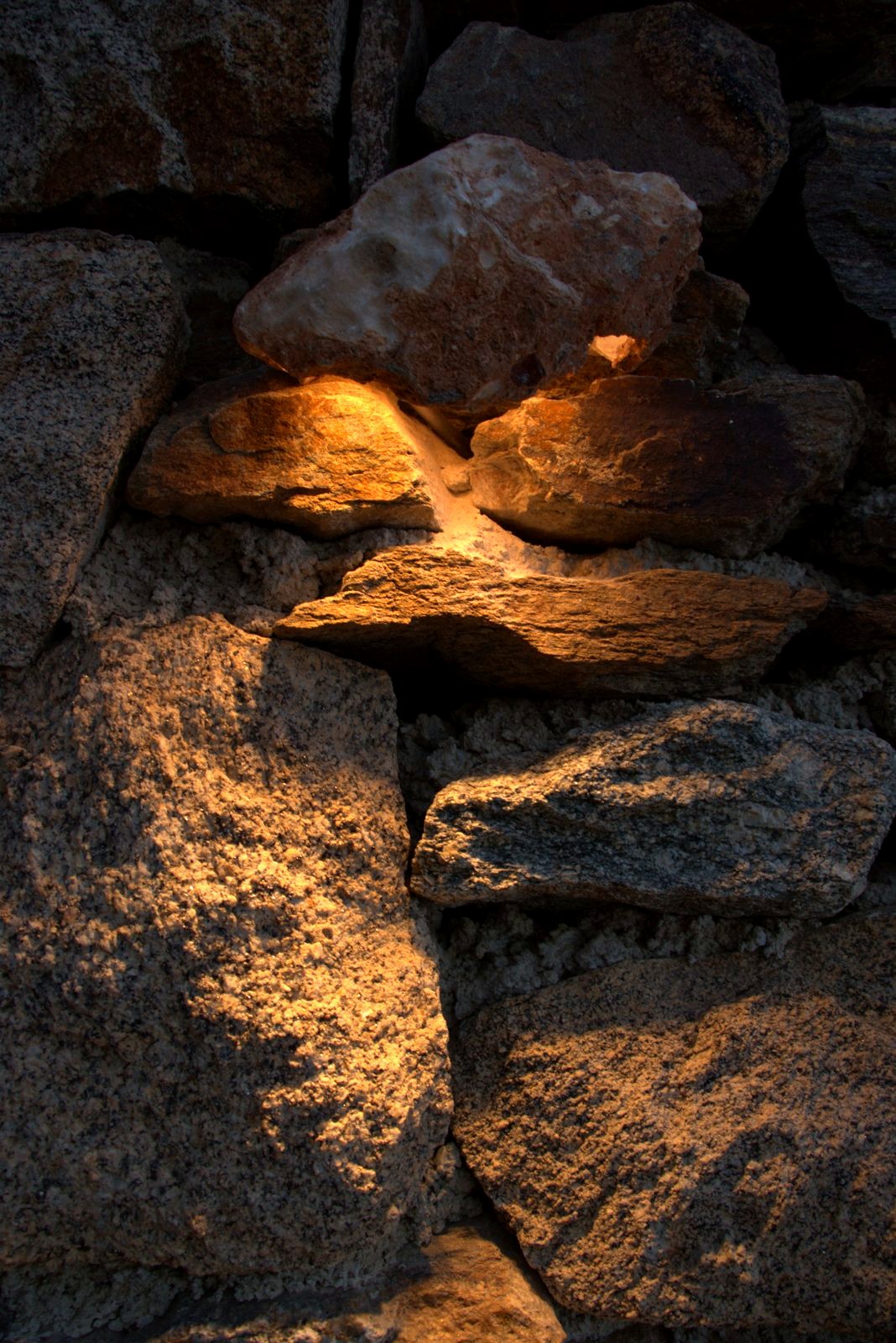 Warm light hidden between the rocks of a dry stone wall at Alemàgou.